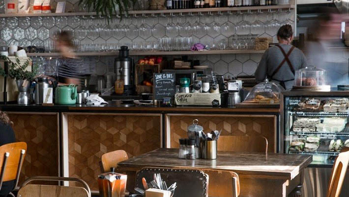 Coffee shop worker making coffee and drinks behind the counter