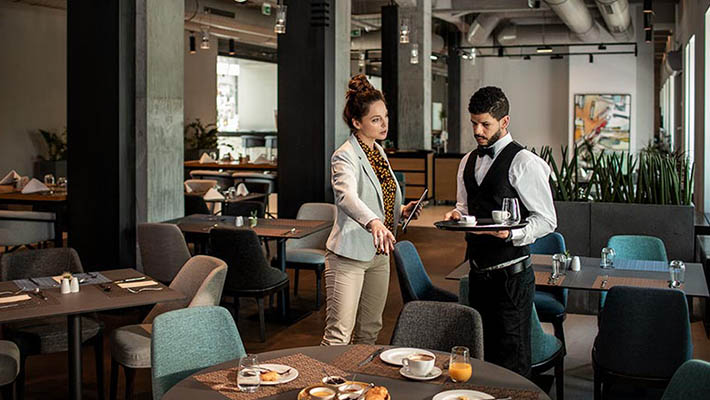 Restaurant manager talking to staff and giving instructions