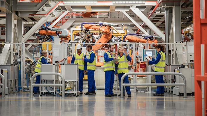 Group of factory workers discussing about storage in logistics warehouse