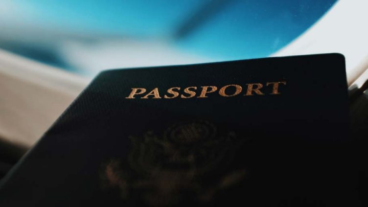 Bottom view of mini book with black cover and passport engraved on it.