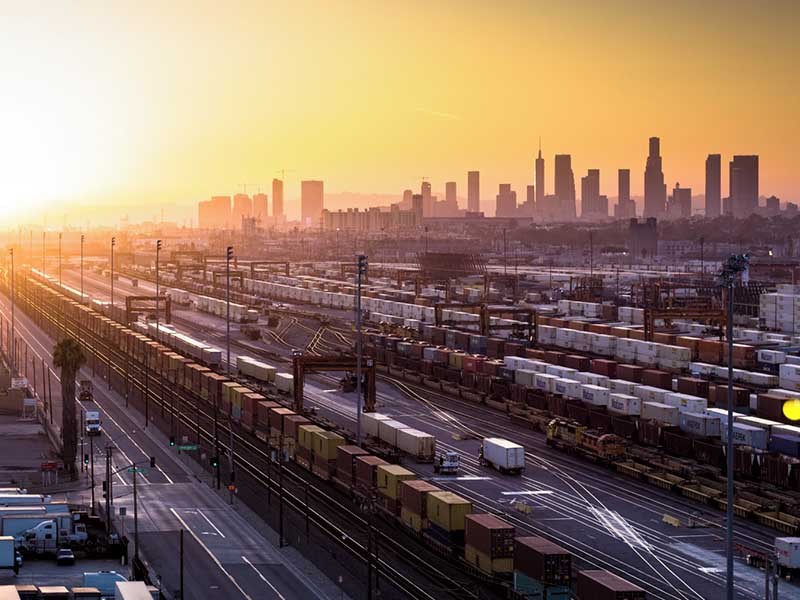 This is a sunset aerial shot of an industrial area made up of factories and warehouses surrounded by the City of LA.