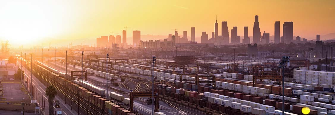 This is a sunset aerial shot of an industrial area made up of factories and warehouses surrounded by the City of LA.