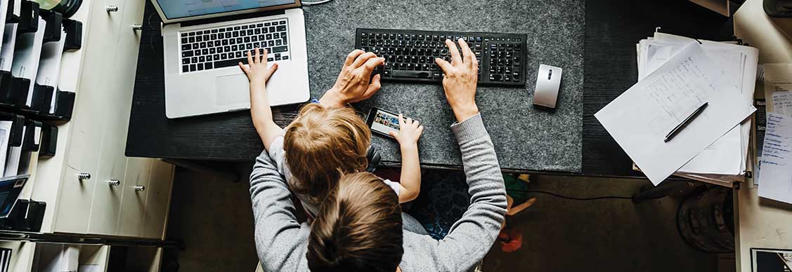 Young mother working from home with a child on her lap