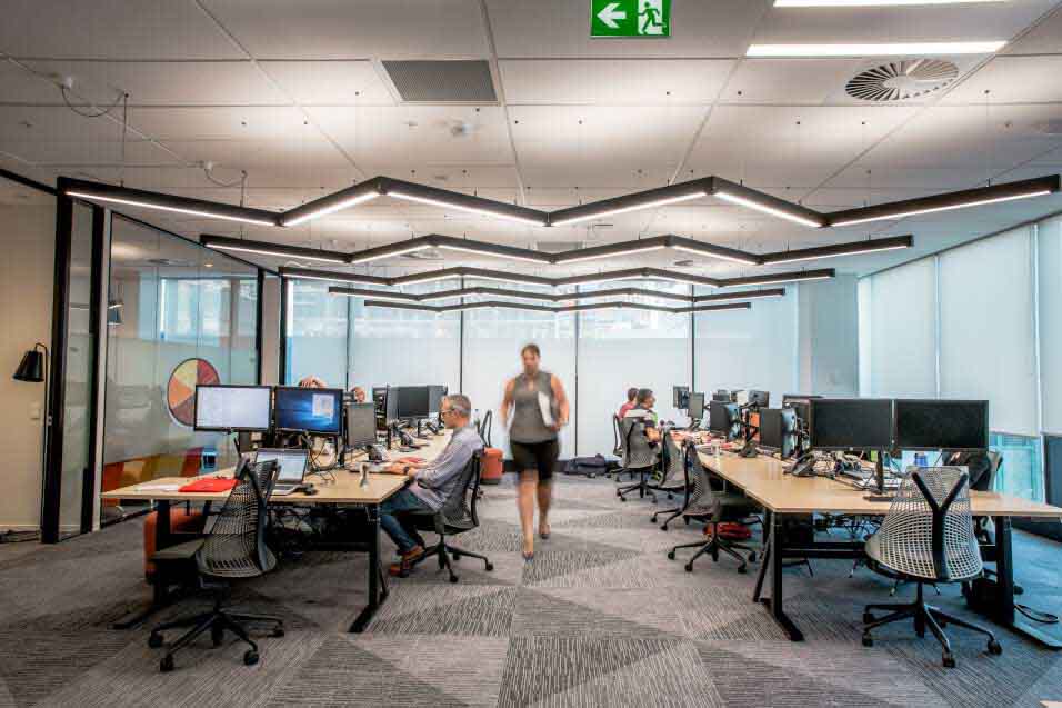 Side view of employees working on computers while sittng in modern office open space