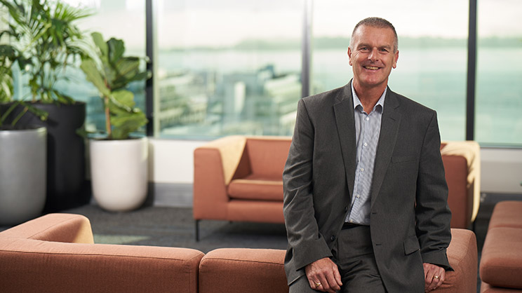 Man sits on couch in office building.