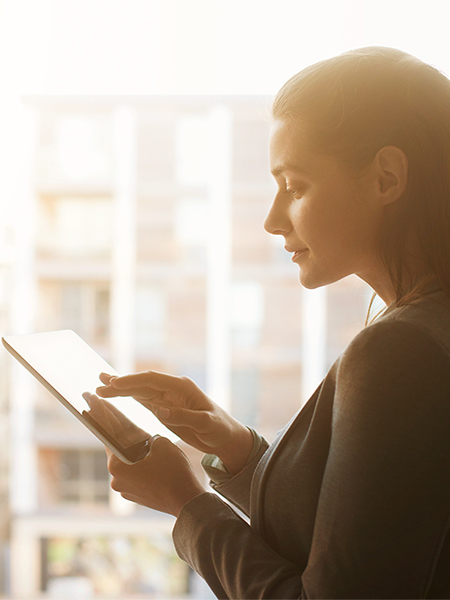 A young woman using a tablet near a window at an office