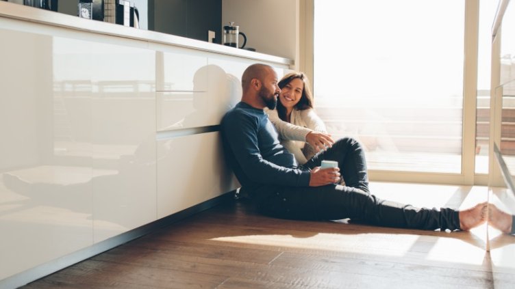 Couple sitting on the floor engaged in conversation with each other