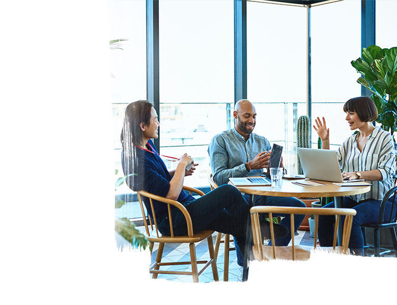 People working around a café table on their laptops