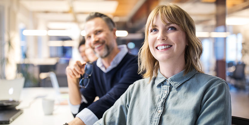 Smiling young woman listening a presentation