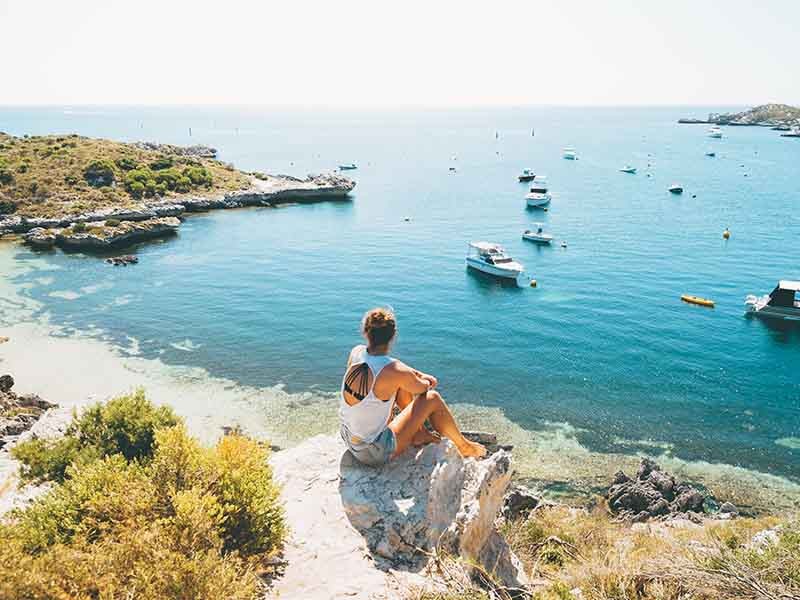 A seated young lady overlooking the cliff 