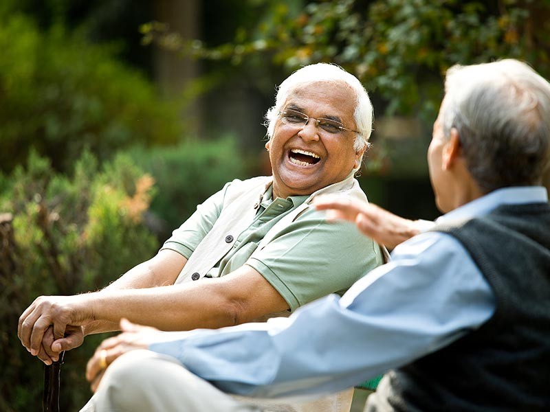Two senior men discussing on park bench