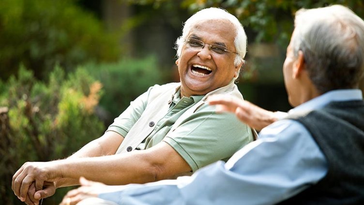 Two senior men discussing on park bench