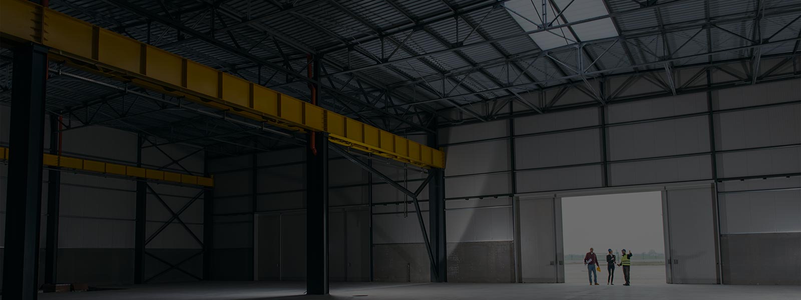 Three people discussing while looking inside a warehouse