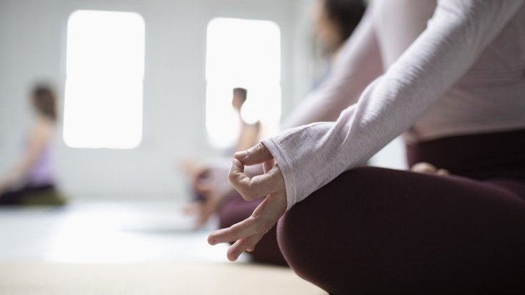 People doing Yoga while sitting on their mats